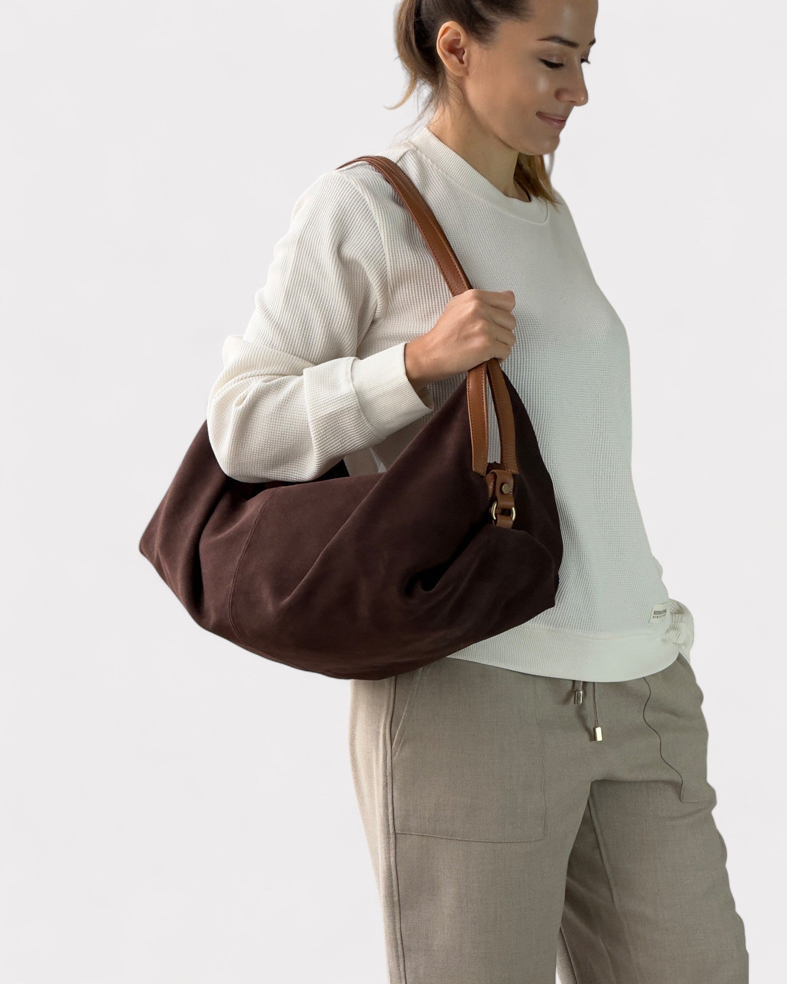Woman holding a brown bag against a white background