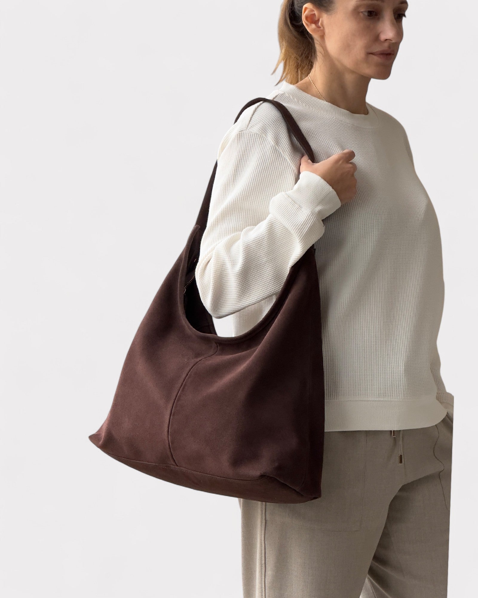 Woman holding a brown bag against a white background
