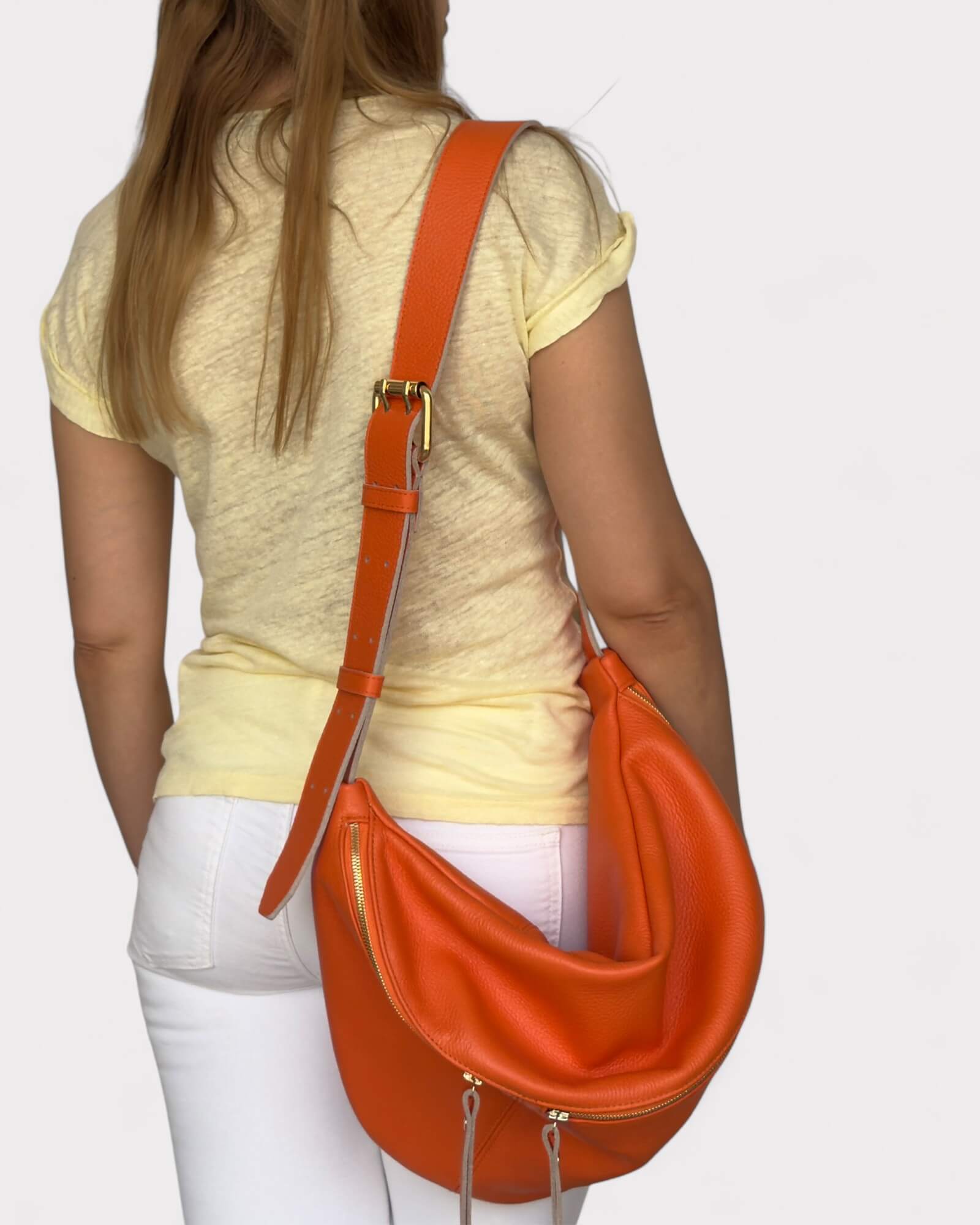 Person wearing  an orange chest bag on a light gray background