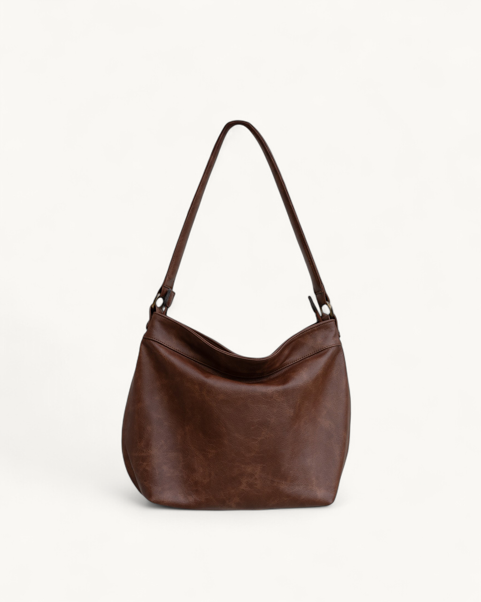 Brown distressed leather handbag on a light beige background